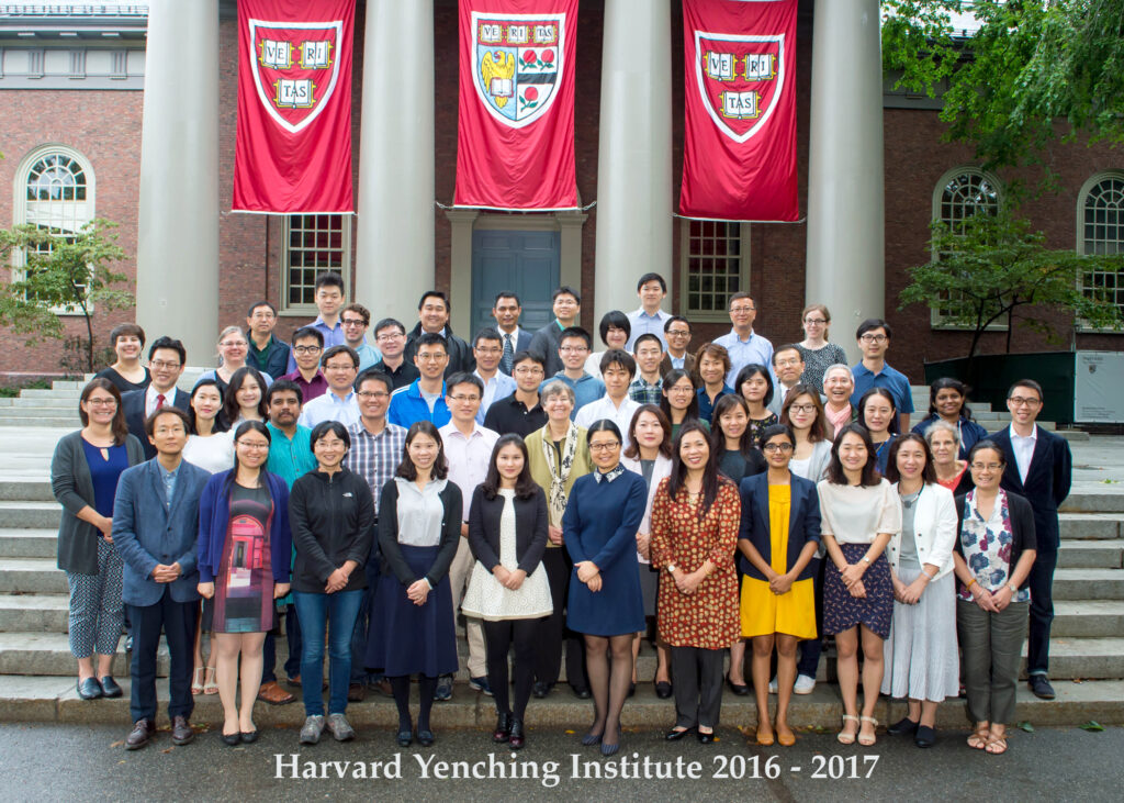 A group of about 40 scholars and fellows poses on steps for a group portrait.