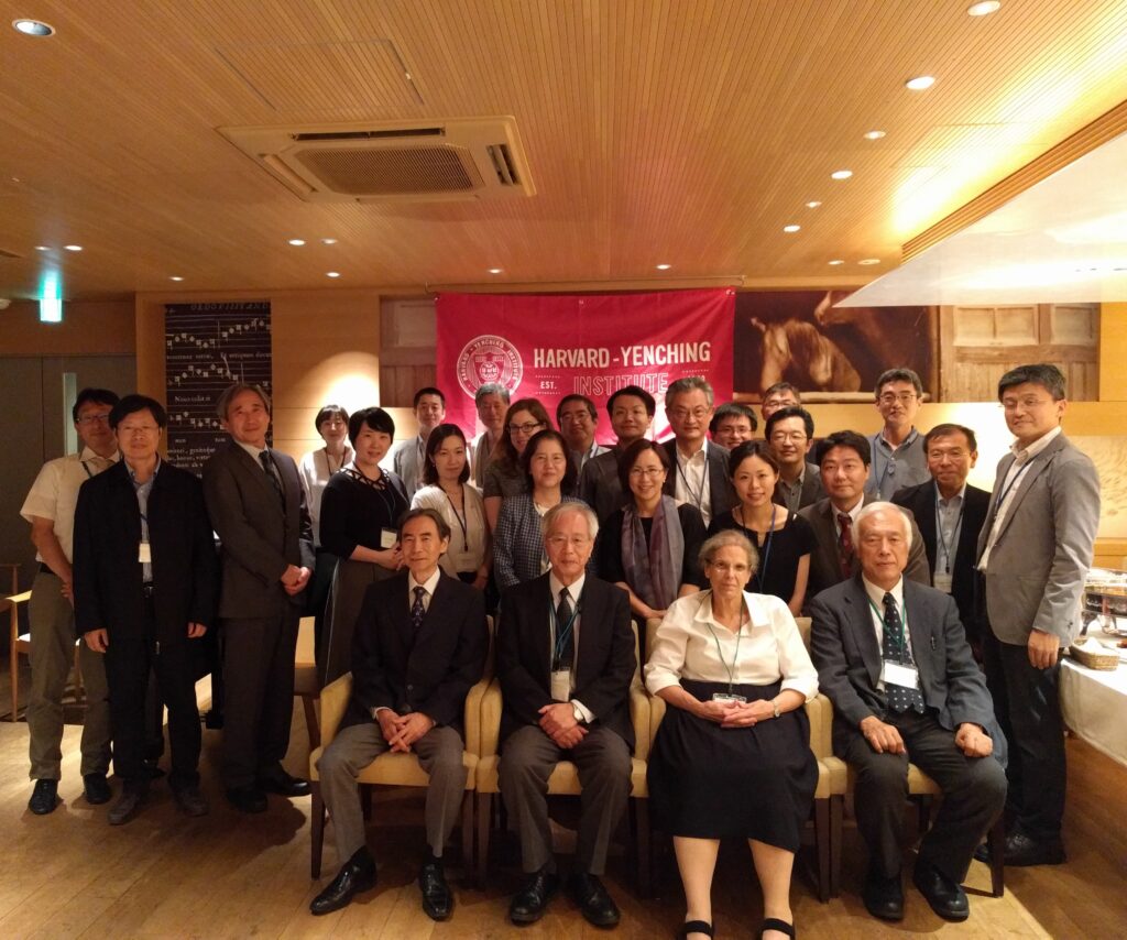 About 20 people pose for a group photo in a restaurant/lounge area.