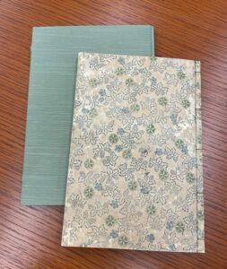 The covers of two books, one teal and one with a floral pattern