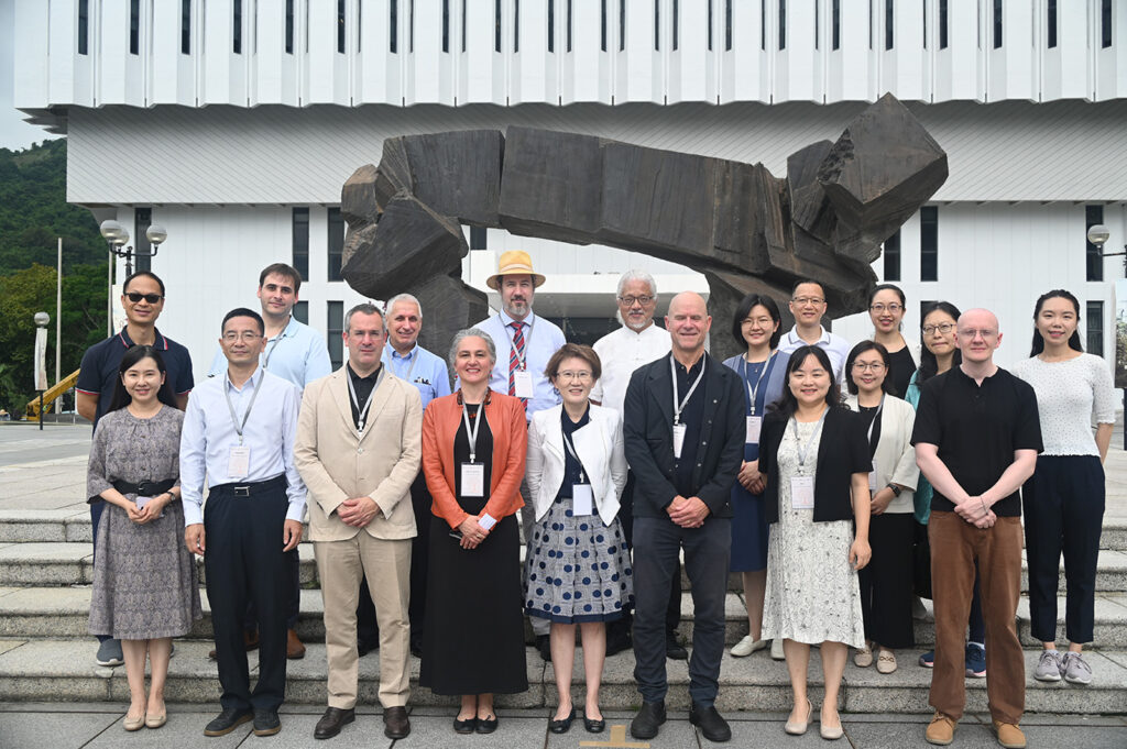 Group photo of conference attendees standing in front of CUHK library