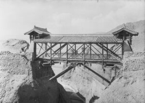 A black and white photo of a wooden bridge over a gorge