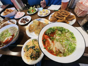 Several different halal Chinese dishes on display at a restaurant table